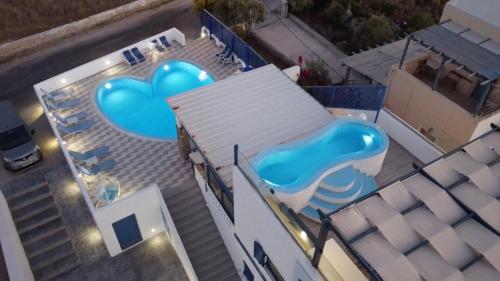 an overhead view of a swimming pool with two blue hearts at Honeymoon Beach Studios in Perivolos