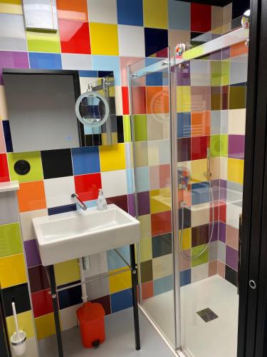 La salle de bains colorée est pourvue d'un lavabo et d'une douche. dans l'établissement la kischte vintage, à Colmar