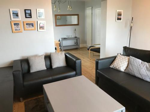 Beamish的住宿－Twizell Lane，客厅配有两张黑色沙发和一张桌子
