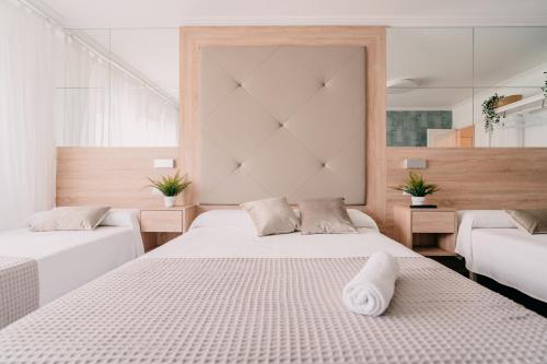 a bedroom with two beds with white sheets at PENSIÓN AUGAS QUENTES in Caldas de Reis
