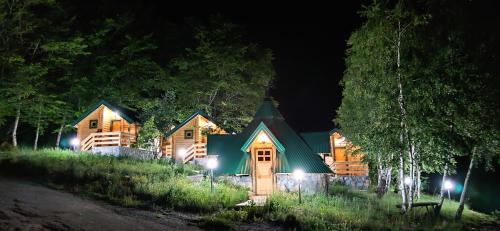 a large log cabin at night with lights at KOZAK Apartments & Restaurant in Mojkovac