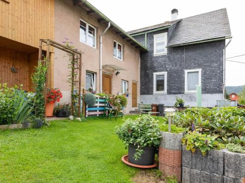 a yard with some plants and a house at Cozy Apartment in Altenfeld with Garden in Altenfeld
