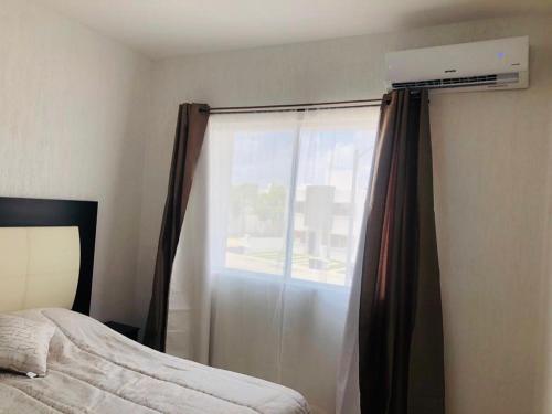 1 dormitorio con 1 cama y ventana con aire acondicionado en La Llar que deseas para vacaciones., en Cancún
