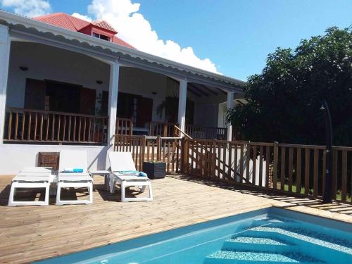 a patio with two chairs and a swimming pool at Villa Thomas bouillante in Bouillante