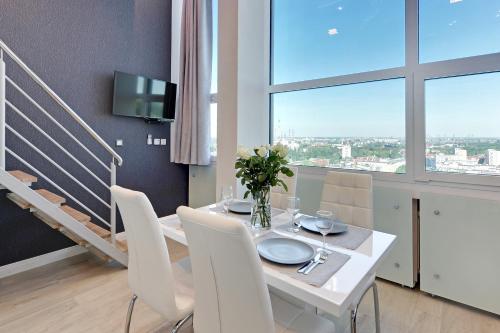 a dining room with a white table and white chairs at Panorama- the View of Gdańsk by Elite Apartments in Gdańsk