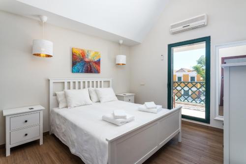 una camera da letto bianca con un letto e una finestra di Holiday house in elite residential area of Faro a Faro