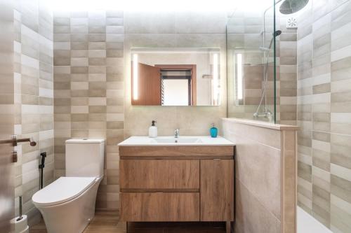 un bagno con lavandino, WC e specchio di Holiday house in elite residential area of Faro a Faro