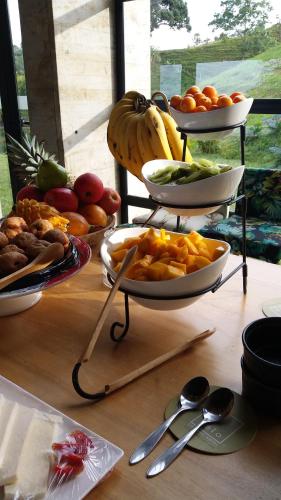 einen Tisch mit Schalen mit Obst und Gemüse in der Unterkunft Casa Du Vélo in Filandia