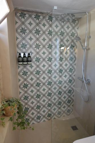 La salle de bains est pourvue d'une douche et d'un mur carrelé. dans l'établissement Apartamento con espectaculares vistas!, à Tarifa