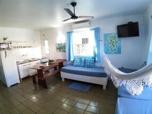 a living room with a blue couch and a kitchen at Pousada Los Casarones in Florianópolis