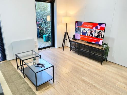 a living room with a flat screen tv at Large Townhouse 5 Beds with Two Parking Spaces - Manchester City Centre in Manchester