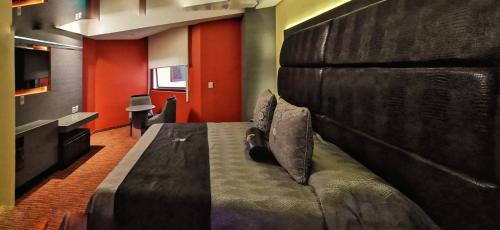 a bedroom with a large bed with a large headboard at Hotel Lua in Mexico City