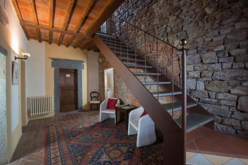a staircase in a room with a stone wall at Rocca Di Castagnoli in Gaiole in Chianti