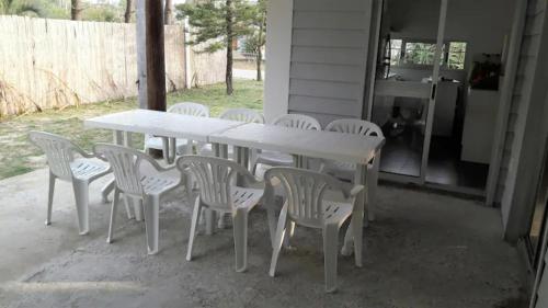 a white table and chairs sitting on a porch at Sabiá in Cuchilla Alta