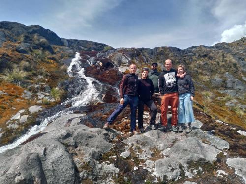 a group of people standing on some rocks near a waterfall at Golden Frog Manizales in Manizales