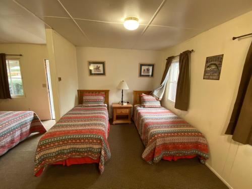 a room with three beds in a room at Independence Courthouse Motel in Independence