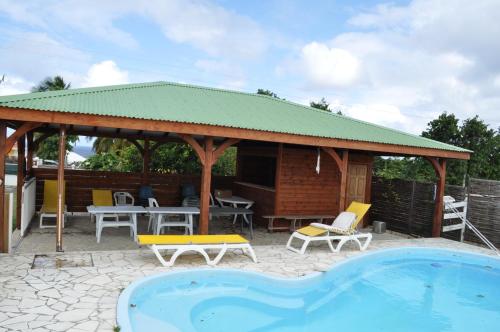 a house with a pavilion and a swimming pool at Domaine de Portland in Le Moule