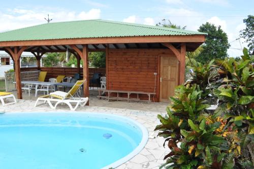 a swimming pool in front of a gazebo at Domaine de Portland in Le Moule