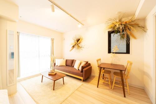uma sala de estar com um sofá e uma mesa em GIVE Higashinakano em Tóquio