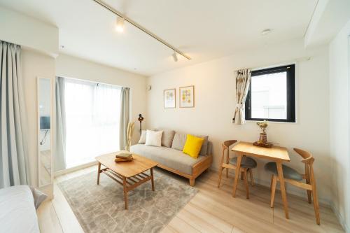 een woonkamer met een bank en een tafel bij GIVE Higashinakano in Tokyo