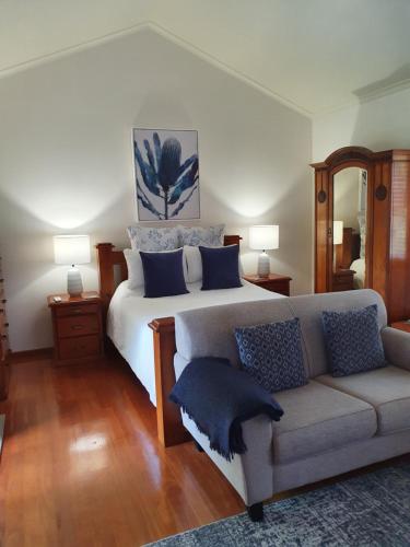 a bedroom with a large bed and a couch at The Paddocks in Maleny
