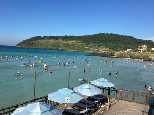 a bunch of people in the water at a beach at Ocean Star Condominium in Seogwipo