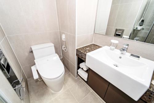 江陵市的住宿－Hi Ocean Gyeongpo，浴室配有白色卫生间和盥洗盆。