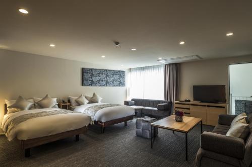 a hotel room with two beds and a flat screen tv at Villa Sanjomuromachi KYOTO in Kyoto