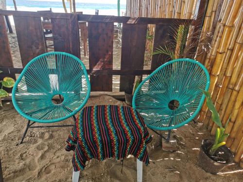 two blue chairs sitting next to a table with a blanket at La Máxima & LGBT in Zipolite