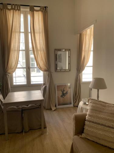 a living room with a table and a window at Apartment Limas in Avignon