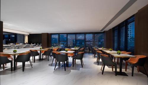 廣州的住宿－柏高酒店（廣州蘿崗科學城金峯地鐵站店），餐厅设有桌椅和窗户。