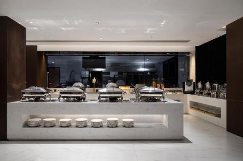 a large kitchen with a counter with several pans at Paco Hotel Jinfeng Metro Guangzhou-Free Shuttle Bus For Canton Fair-Self-service laundry in Guangzhou