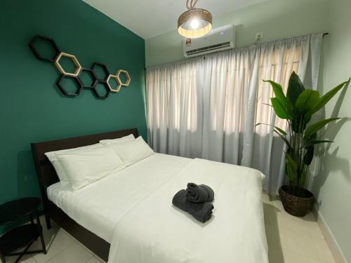 um quarto com uma cama com uma toalha preta em 118-Nineteen Hideout em Shah Alam