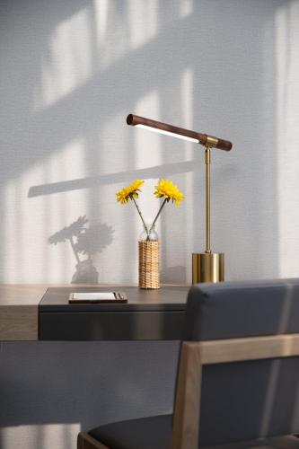 a desk with a lamp and a vase of yellow flowers at Paco Hotel Jinfeng Metro Guangzhou-Free Shuttle Bus For Canton Fair-Self-service laundry in Guangzhou