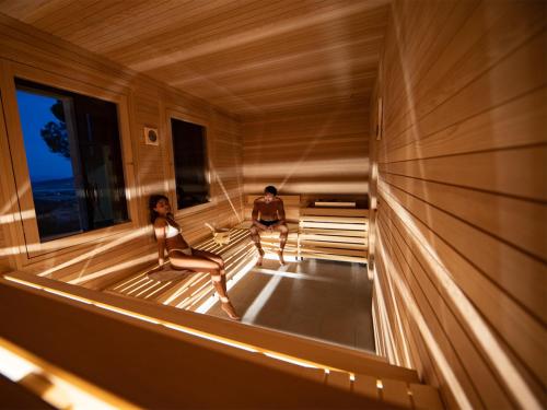 a man and a woman sitting in a sauna at Relais Villa Monte Solare Wellness & SPA in Panicale