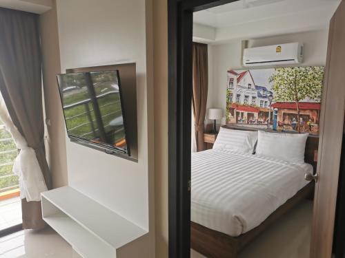- une chambre avec un lit blanc et une fenêtre dans l'établissement APARTMENTS MBC, à Mai Khao Beach
