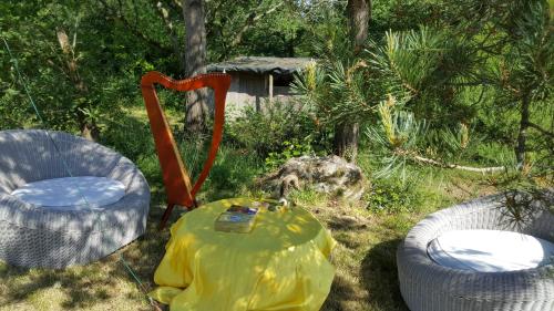 twee stoelen en een tafel in het gras met een tafel bij L'atelier des Fées de l'Aff in Paimpont