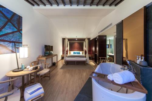 een hotelkamer met een bad en een bed bij Huangshan Demaotang Hotel in Huangshan