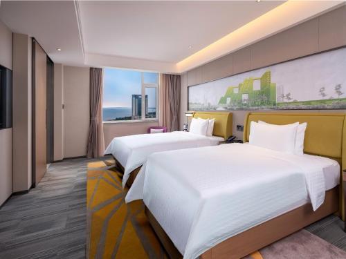 Säng eller sängar i ett rum på Hampton by Hilton Qinhuangdao Jinmeng Bay