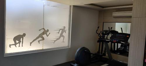 a gym with a painting of people on the wall at Ginger Vadodara RCR in Vadodara