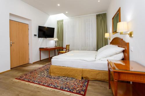 a hotel room with a bed and a desk at Stylové ubytování v historickém centru Litomyšle in Litomyšl