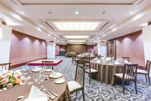 a banquet room with tables and chairs and flowers at ANA Crowne Plaza Fukuoka by IHG in Fukuoka