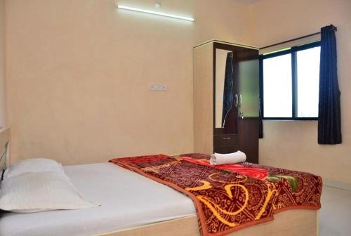 ein Schlafzimmer mit einem Bett mit einer Decke darauf in der Unterkunft Savitri bungalow 3BHK in Panchgani
