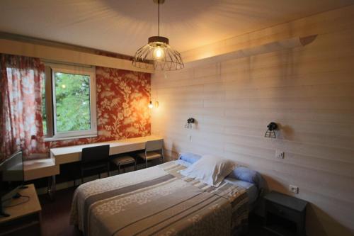 a bedroom with two beds and a window at Le France in Loudéac