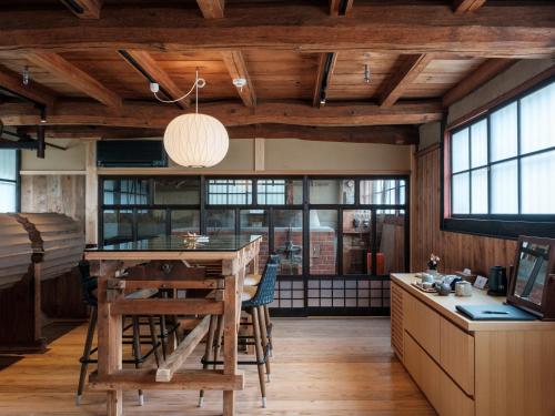 a kitchen with wooden ceilings and a table and chairs at NIPPONIA HOTEL Yamefukushima Merchant Town in Ita