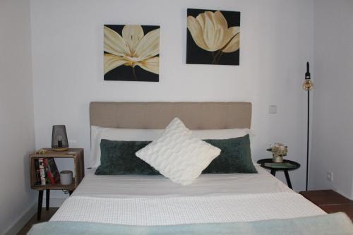 - une chambre avec un lit blanc et des oreillers verts dans l'établissement La Casa Toledana Estudio - Patio y Artesonado, à Tolède