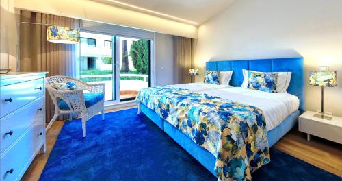 a bedroom with a blue bed and a window at Victory Village 18E in Quinta do Lago