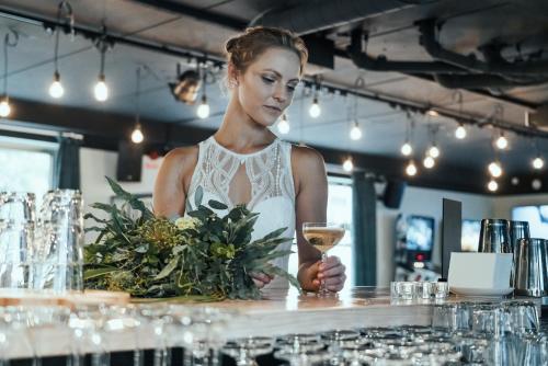 a woman standing behind a counter with a glass of wine at Botanika Uppsala in Uppsala