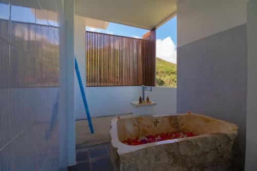 Habitación con baño con bañera de piedra grande. en Villa Nambung en Selong Belanak