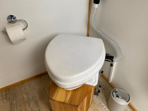ein weißes WC im Bad mit einem Schlauch in der Unterkunft Tauber Glamping Mobil in Tauberbischofsheim